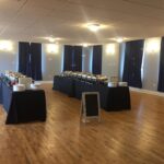 A room with tables and chairs set up for a buffet.