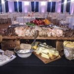 A buffet table with a variety of meats and cheeses.