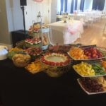 A buffet table with fruit and desserts on it.