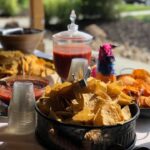 A table with chips and salsa on it.