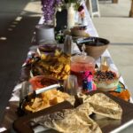 A long table with food and flowers on it.