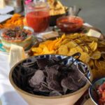 A bowl of chips and salsa on a table.