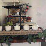 A table with candles, fruit, and eucalyptus.