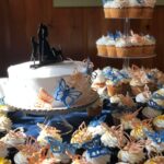 A white cake with blue and orange butterflies on it.