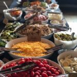 A buffet with a variety of salads and vegetables.