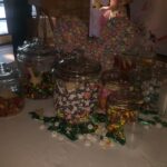 A table full of candy jars on a table.