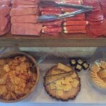 A buffet of meats and cheeses on a table.