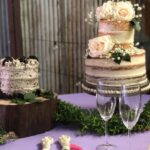 Two wedding cakes on a purple table.