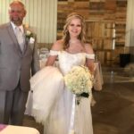 A bride walks down the aisle with her father.