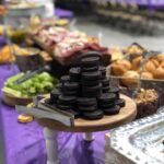 A purple table with a variety of food on it.