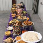 A long table full of food in a warehouse.