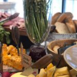 A buffet with a variety of meats and cheeses.