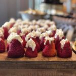 Strawberries with whipped cream on a wooden board.