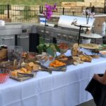 A little girl standing in front of a buffet table.