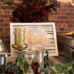 A buffet table with roses and flowers on it.