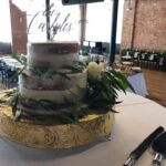 A wedding cake is sitting on a table in a room.