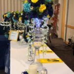 A table set up with blue and yellow flowers.