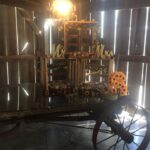 A wagon decorated with sunflowers in a barn.