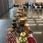 A long table of desserts in a conference room.