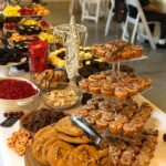 A long table with a variety of desserts on it.