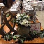 A table with flowers and candles on it.