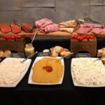 A buffet with a variety of meats and cheeses.