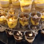 A display of desserts in cups on a table.