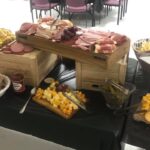 A buffet of meats and cheeses is on a table.