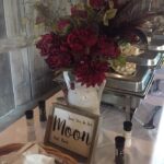 A buffet table with flowers and baskets on it.