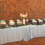 A buffet table with a blue tablecloth.