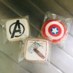 Three cookies with avengers logos on them.