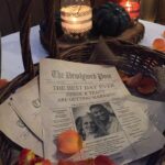 A wicker basket filled with newspapers and flowers.