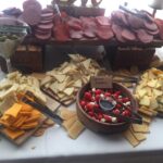 A table with a variety of cheeses and crackers.