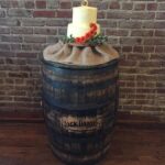 A wedding cake is sitting on top of a barrel.