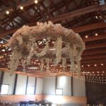 A chandelier hanging from the ceiling of a barn.