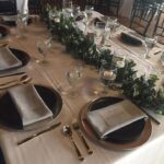 A table set up with place settings and silverware.