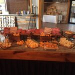 A table with a variety of cheeses on it.