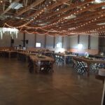 A large barn with tables and chairs set up for a wedding reception.