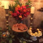 A table with desserts and flowers on it.