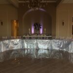 A silver table set up in a banquet hall.