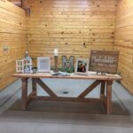 A wooden table with signs on it in a barn.