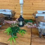 A wooden table with trays of food on it.