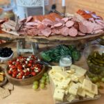 A table with a variety of meats and cheeses.