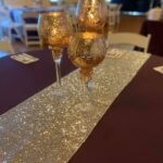 A table runner with gold sequins on it.