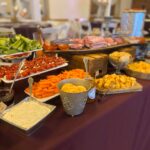 A buffet table with a variety of food on it.