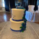 A wedding cake with a blue peacock on top.