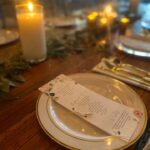 A table setting with candles and a menu.