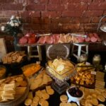 An assortment of cheeses and crackers on a table in front of a brick wall.