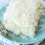 Coconut cake on a plate with a fork.