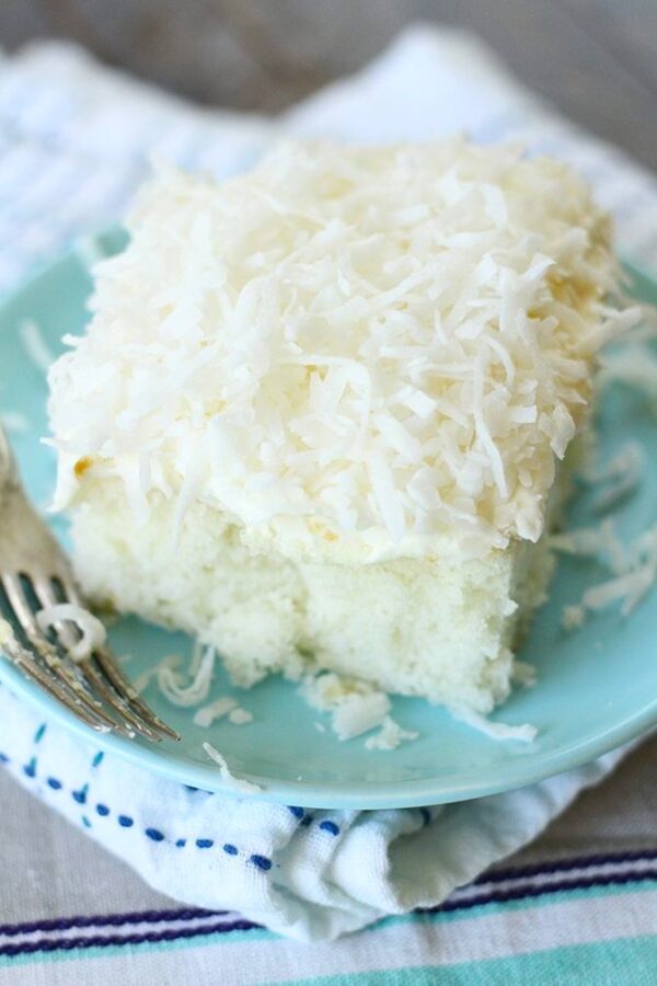 Coconut cake on a plate with a fork.